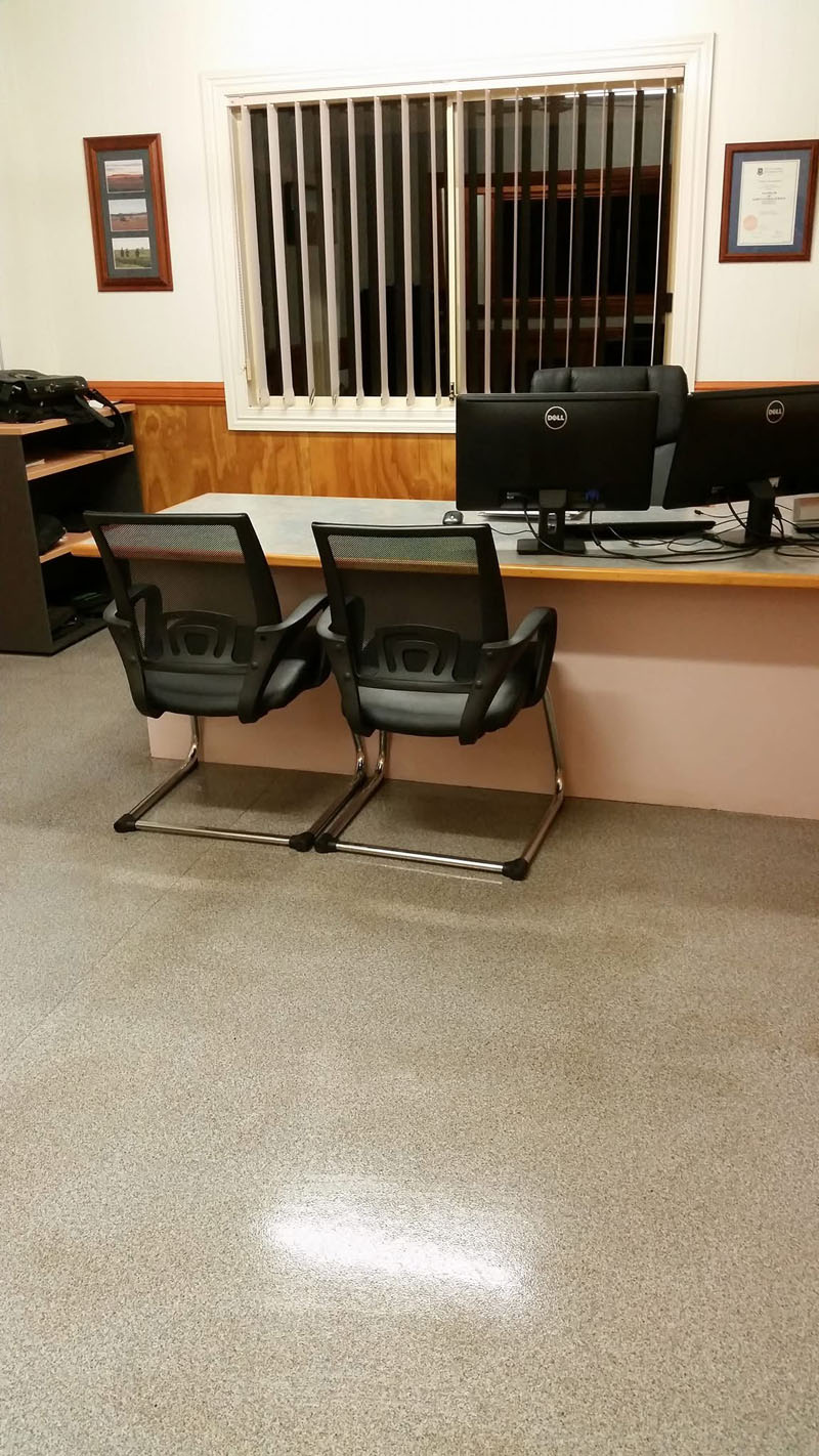 Shiny speckled floor in front of a reception desk with two visitor chairs