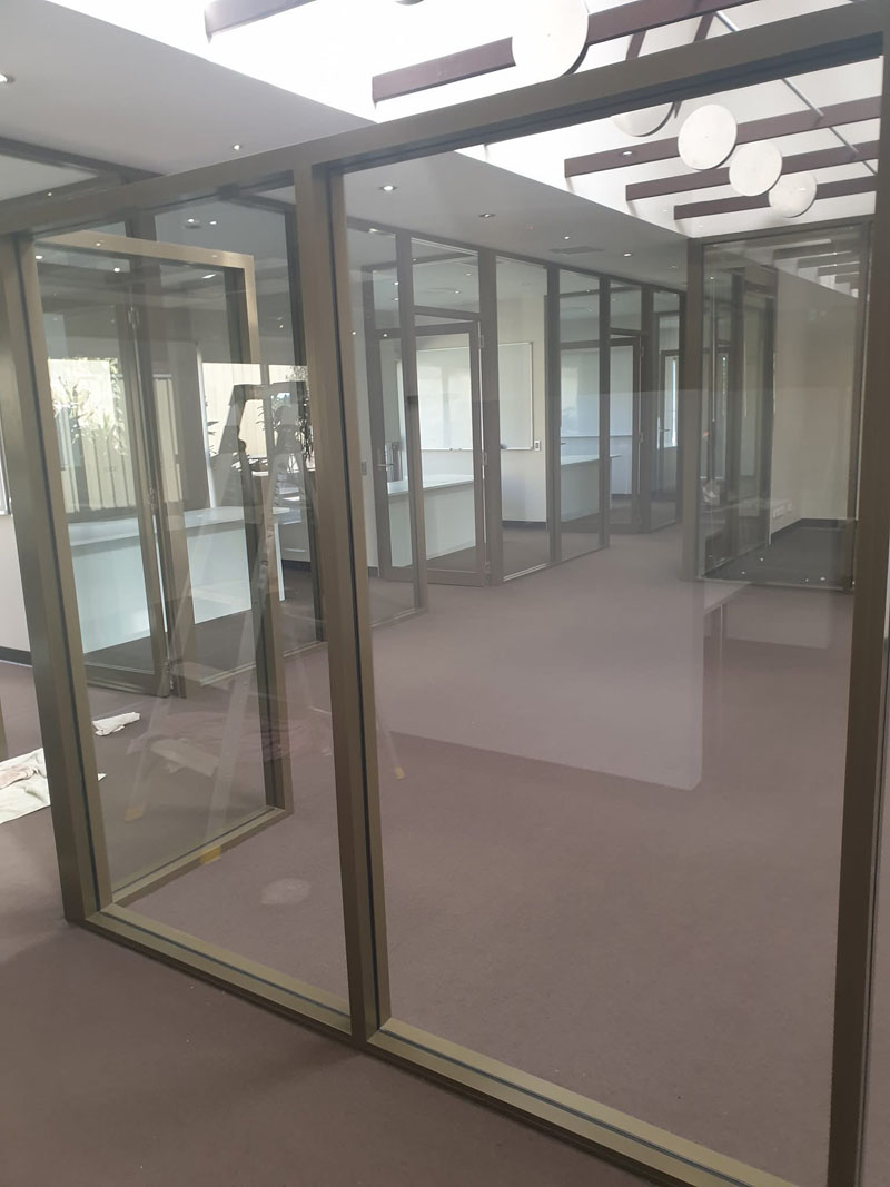 Empty office corridor lined with glass partition walls