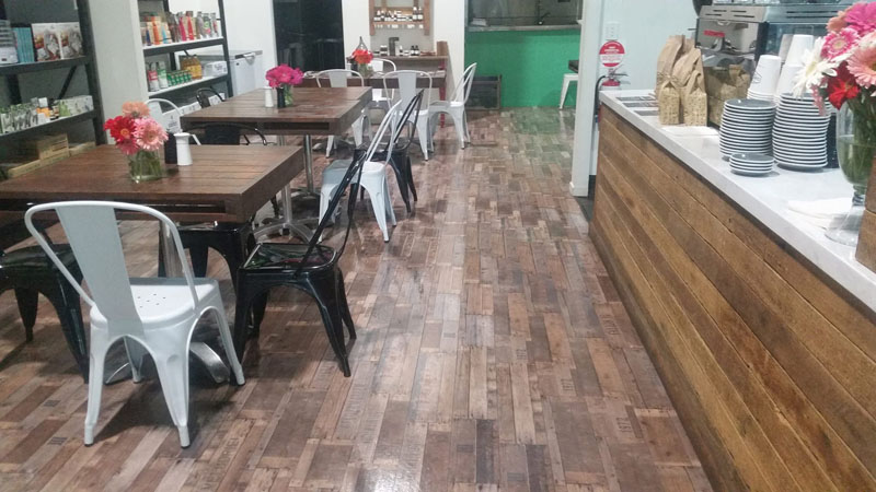Café with timber tables, metal chairs and a glossy timber-look tiled floor